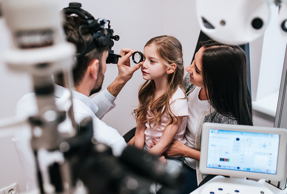 Child at an eye exam with her mother