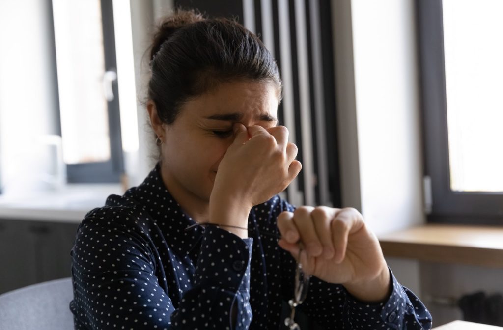 A woman taking a break from her work due to irritation from dry eye