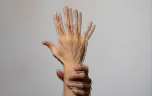 A blurred hand showing what a person who needs neurolens glasses would see as double vision is a common symptom of eye misalignment