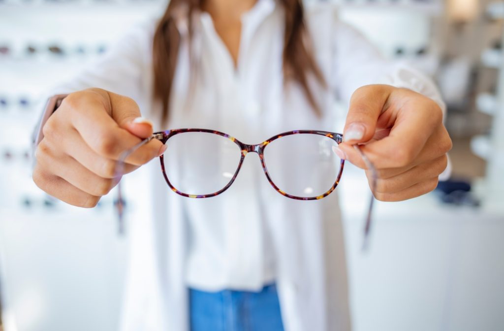 A female optometrist holding a pair of neurolens glasses