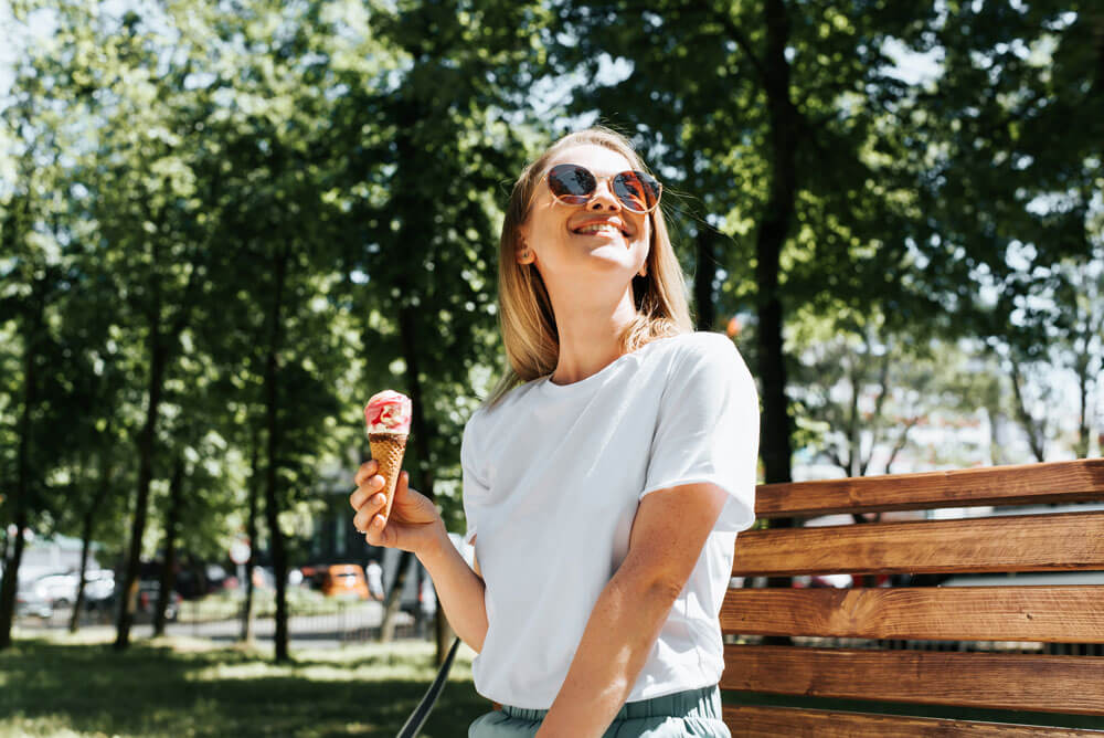 Woman wearing sunglasses holding her ice cream